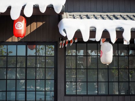 Japanese lantern hung in front of Japanese Restaurant, Japanese text on lantern is "Sushi" Japanese food.