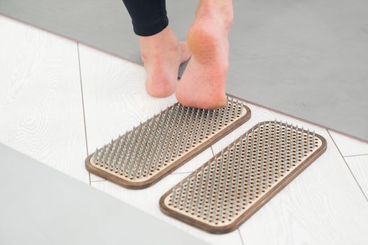 A woman comes down from the sadhu boards. Close-up of feet with prints after nails