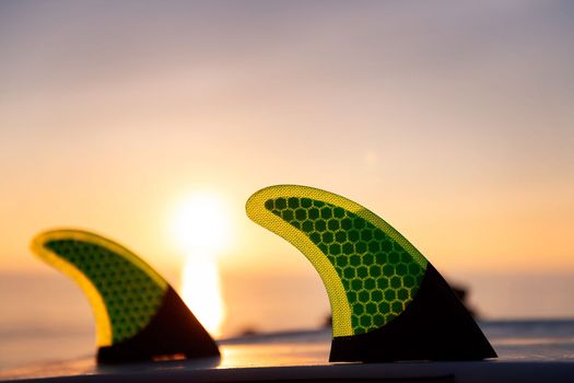 fins of a surf board at sunset, leisure and hobbies concept, copy space for text