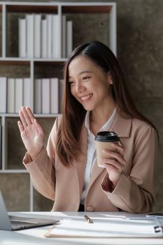 Smiling asian business woman with laptop computer in office. Woman in suit at office.