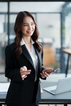 business owner or Asian female marketers are using business phones in office work.