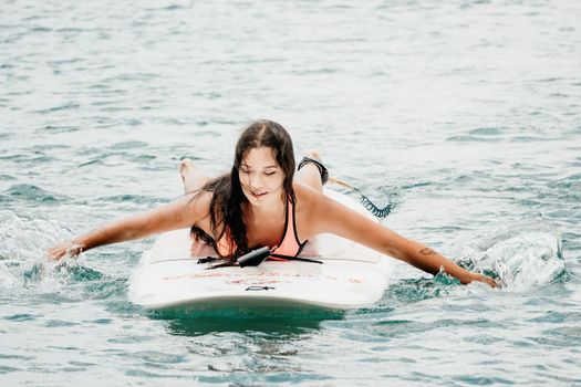 Sea woman sup. Silhouette of happy young woman in pink bikini, surfing on SUP board, confident paddling through water surface. Idyllic sunset. Active lifestyle at sea or river. Slow motion