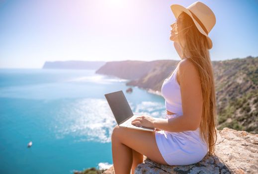 Happy girl doing yoga with laptop working at the beach. beautiful and calm business woman sitting with a laptop in a summer cafe in the lotus position meditating and relaxing. freelance girl remote work beach paradise