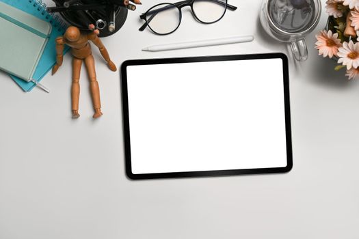 Top view, digital tablet with blank screen on white office desk.
