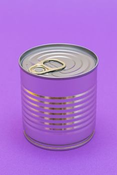 Unopened Tin Can with Blank Edge on Violet Background. Canned Food. Aluminum Can for Safe and Long Term Storage of Food. Steel Sealed Food Storage Container