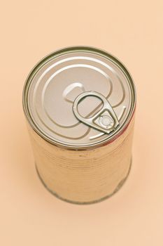 Unopened Tin Can with Blank Edge on Beige Background. Canned Food. Aluminum Can for Safe and Long Term Storage of Food. Steel Sealed Food Storage Container