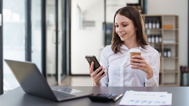 Smiling asian business woman with smartphone in office. Woman in casual at office.