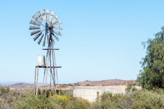 A typical Karoo landscape, with a windmill, water tank and dam, on road R356 between Loxton and Fraserburg in the Northern Cape Karoo