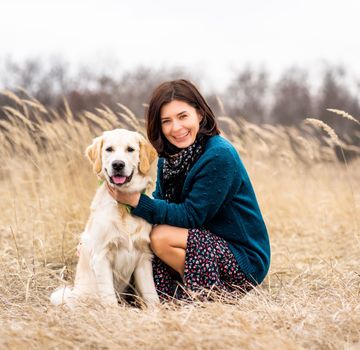 Cheerful woman with devoted dog in early spring nature