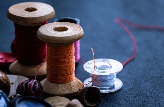 Bobbins of threads standing near buttons and beads