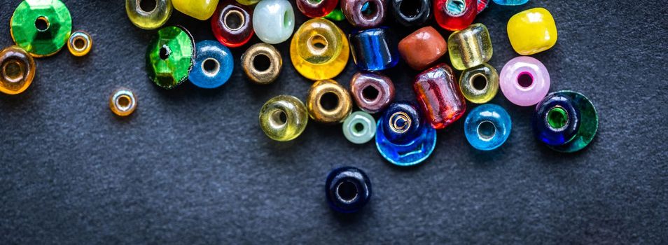 Top view of colorful glass beads on a black background