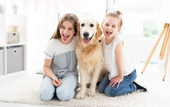 Funny Portrait of little girls with cute dog in bright room