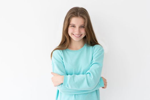 Portrait of smiling teenage girl on a wall background