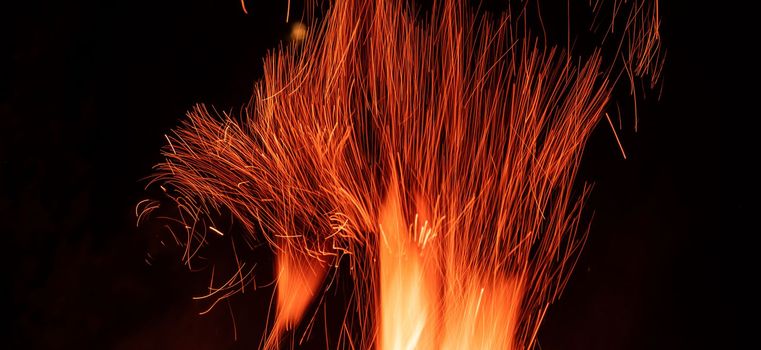 Beautiful red orange stripes of fire flame isolated on black background. Abstract composition of bonfire sparks