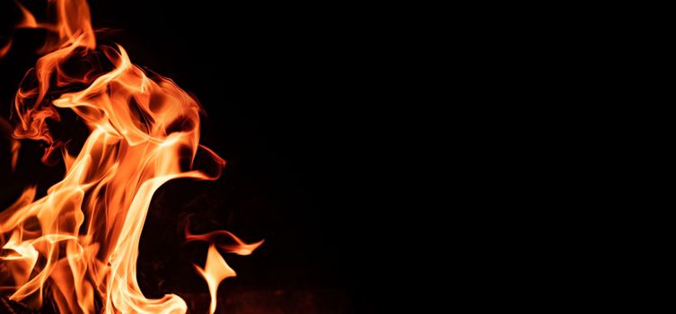 Beautiful abstract flame from bonfire on the nature in the night. Orange fire tonques isolated on black background