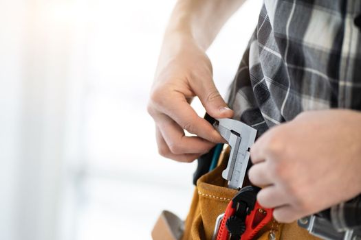 Hand of master pulling out caliper from mounting belt