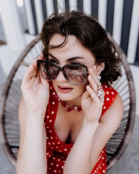 Close-up portrait of a woman with glasses. Photo of a fashionable girl with beautiful brown hair