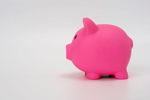 Piggy bank pink on a white background. Symbol saving or accumulation of money. The concept of Financial literacy. Investments and savings. side view