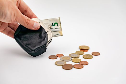 Hand with wallet and small euro banknotes and euro coins