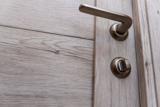 beautiful new steel handle of the interior door in the apartment. Close-up of the exterior of the bathroom door