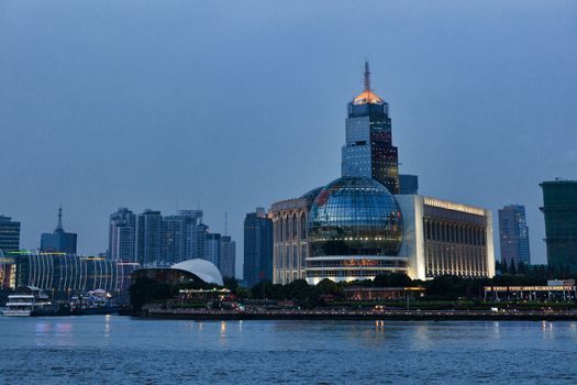 Shanghai skyscrapers near water at night with mirror