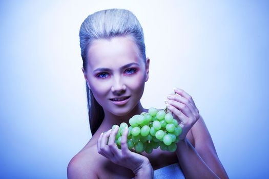 Cold young woman take frozen grapes portrait