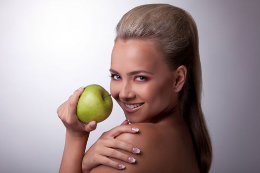 Pretty young girl posing with green apple