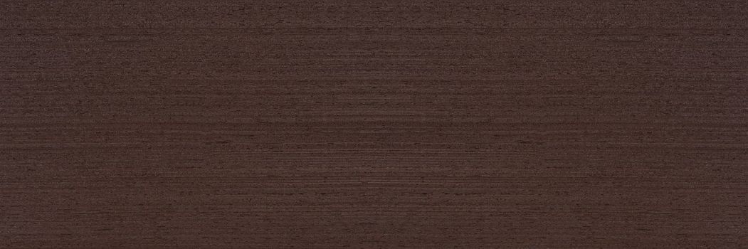 Texture of wenge wood. Dark brown wenge background. Natural brown wood texture, solid natural wood for furniture production.