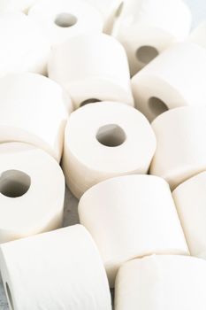 New white toilet paper rolls on a gray background.