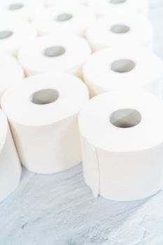 New white toilet paper rolls on a gray background.