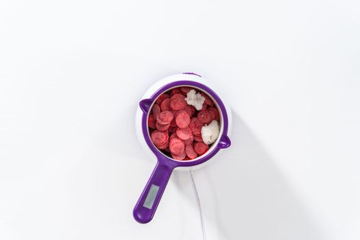 Flat lay. Melting chocolate chips in a candy melting pot to make chocolate-covered pretzel rods for Valentine's Day.