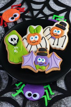 Happy Halloween with funny characters on gingerbread cookies; bat, ghost and spiders. Trick or treat. Traditional, party and holiday concept