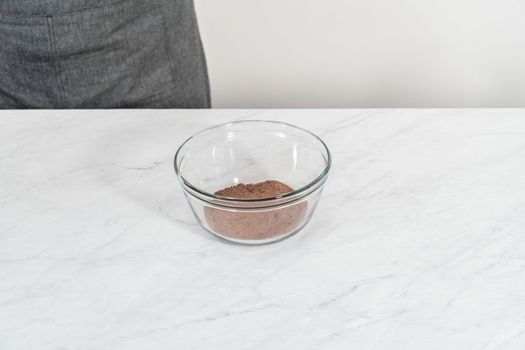 Mixing ingredients in a glass mixing bowl to bake chocolate graham crackers.