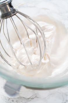 Mixing ingredients in kitchen mixer to bake Easter meringue cookies.