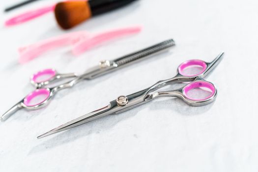 New barber pink scissors on a gray background.
