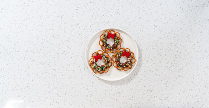 Flat lay. Chocolate pretzel Christmas wreath on a white plate.