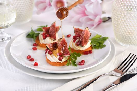 Roasted sweet potato rounds as a vegetarian snack. Perfect for a festive feast, they are topped with creamy whipped yogurt feta, juicy figs and honey and pomegranate. Vegetarian Gluten Free