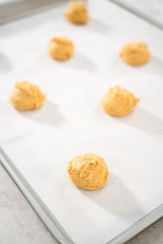 Scooping dough with dough scoop to bake eggnog scones.