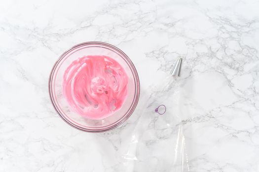Mixing pink food coloring into the meringue to bake Easter meringue cookies.
