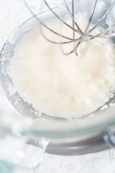 Mixing ingredients in kitchen mixer to bake Easter meringue cookies.