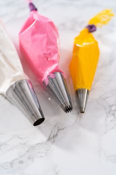 Meringue in piping bags with metal piping tips to pipe Easter meringue cookies.