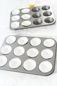 Lining cupcake pan with foil cupcake liners to bake s'mores cupcakes.