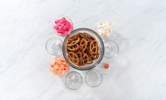 Flat lay. Measured ingredients in glass mixing bowls to prepare chocolate-covered pretzel twist.