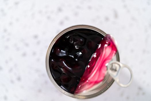 Opened a metal can with blueberry pie filling on the counter.