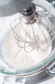 Mixing ingredients in kitchen mixer to bake Easter meringue cookies.