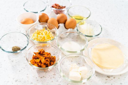 Measured ingredients in glass mixing bowls to make breakfast empanadas with eggs and sweet potato.