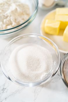 Measured ingredients in glass mixing bowls to bake mini vanilla cupcakes with ombre pink buttercream frosting.
