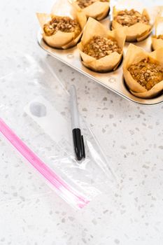 Meal prepping. Packaging banana oatmeal muffins into the plastic back to store in a freezer.