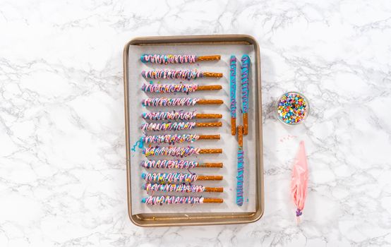 Mermaid chocolate pretzel rods drizzled with pink and purple chocolate and covered with sprinkles.
