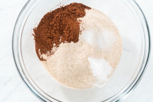 Mixing ingredients in a glass mixing bowl to bake chocolate graham crackers.